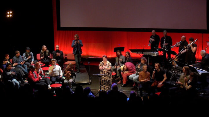 Bild från radioverkstan live, människor på scen inför publik.